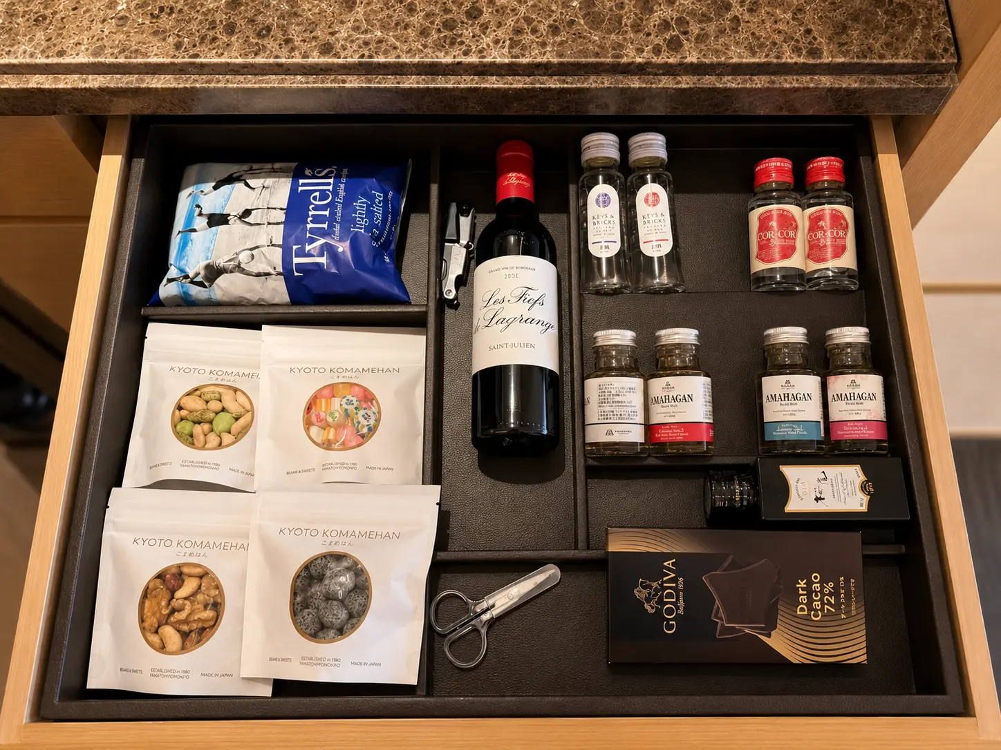 Minibar drawer at Four Seasons Hotel Kyoto with Japanese snacks, wine, spirits and Godiva chocolate.