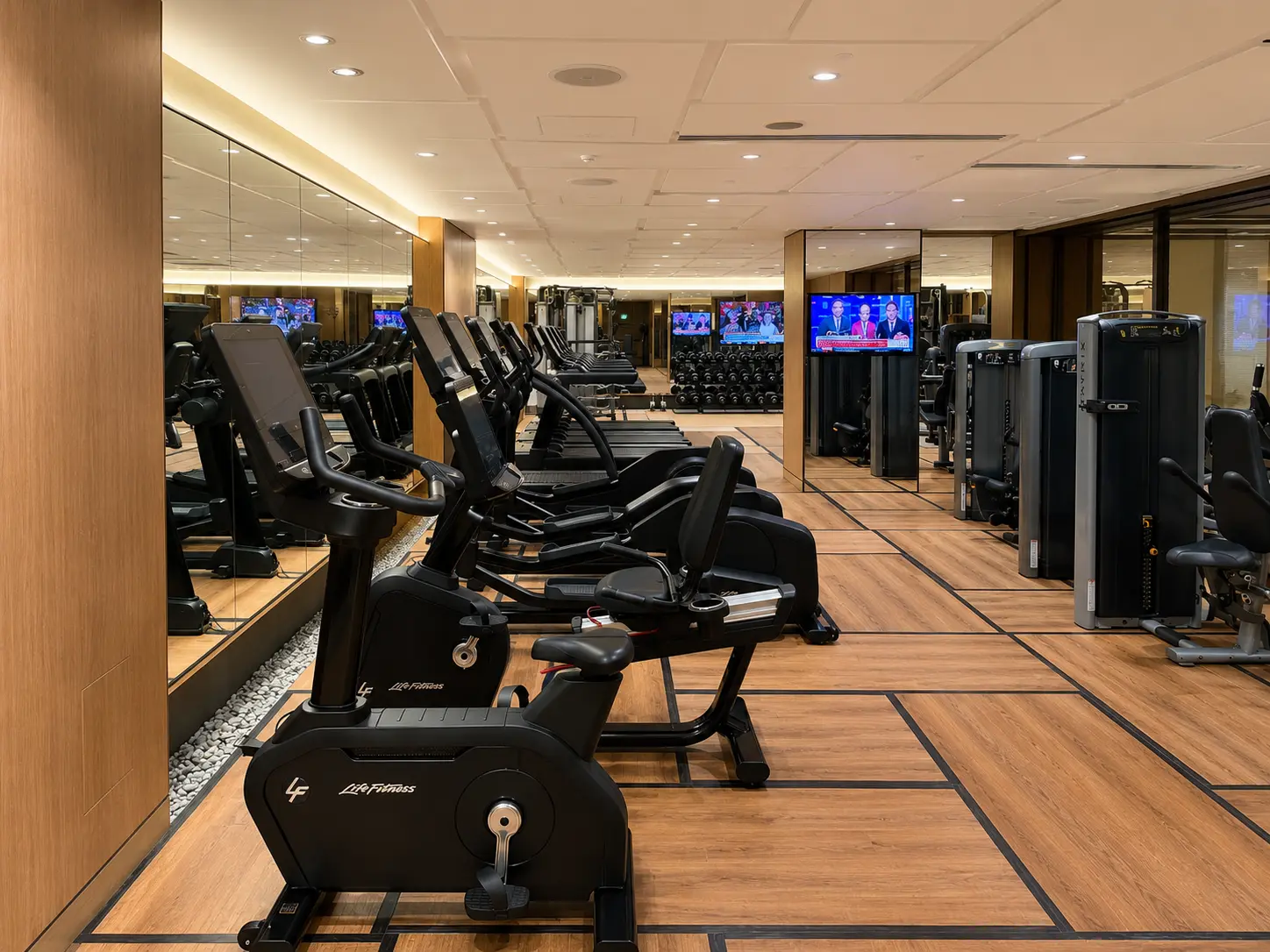 Cardio area at the Four Seasons Hotel Kyoto fitness center with exercise bikes, cardio machines and strength equipment.
