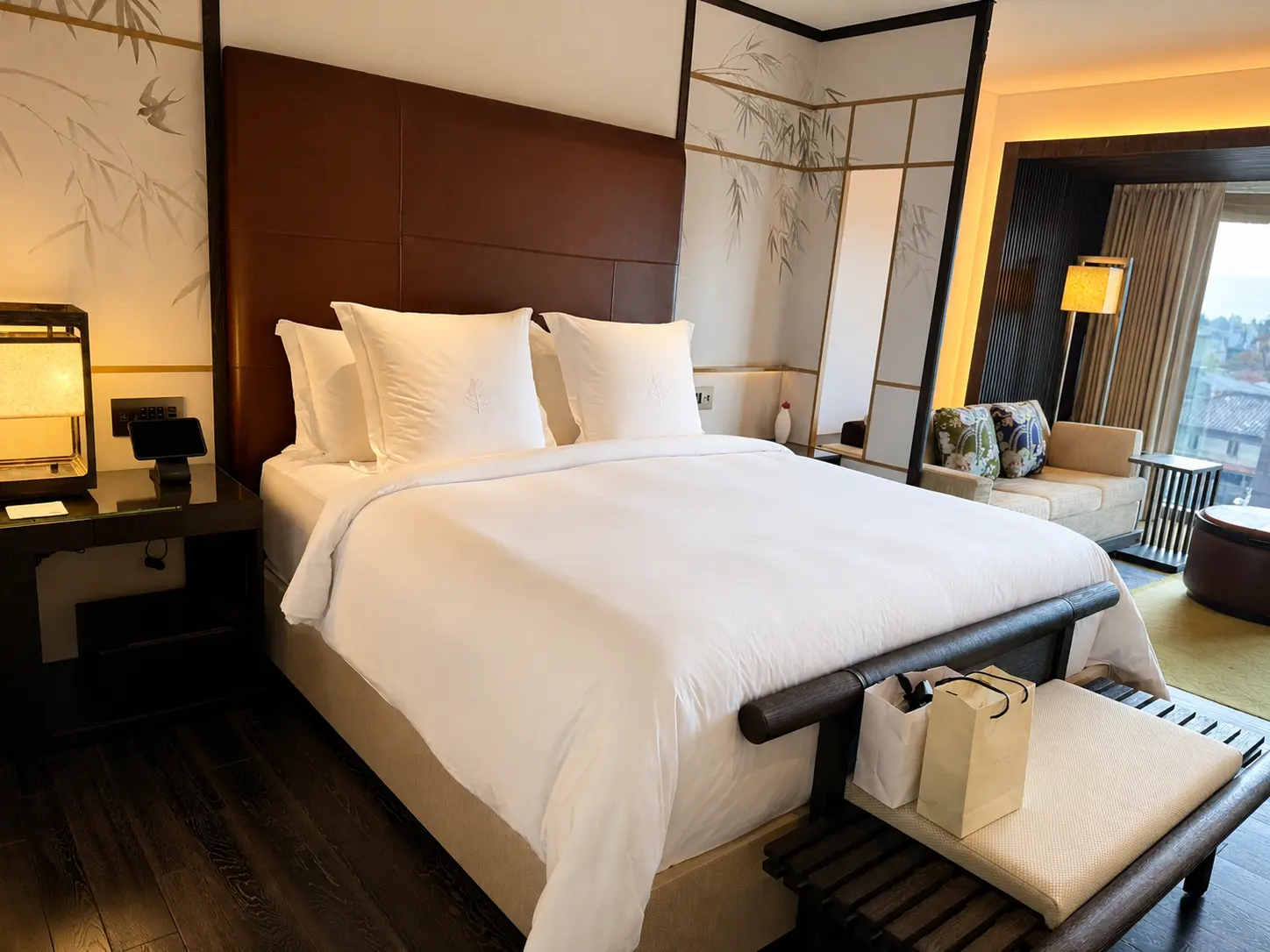 Four Seasons Hotel Kyoto guest room with Japanese fusuma-e panels depicting bamboo and birds behind the bed.