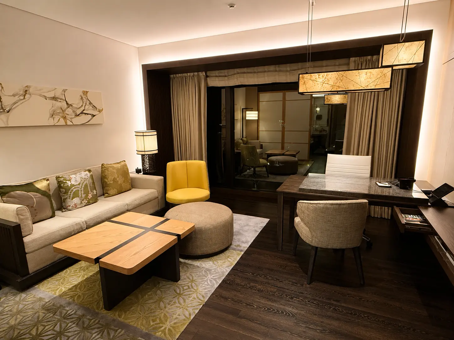 Living room inside a residence at Four Seasons Hotel Kyoto with sofa, dining table, desk and Japanese-inspired interior details.