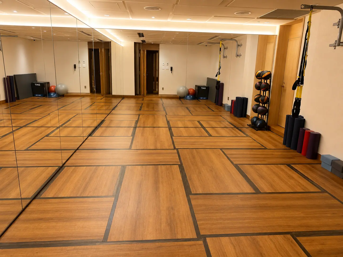 Fitness studio at Four Seasons Hotel Kyoto with mirrored walls, TRX straps, yoga mats and medicine balls.