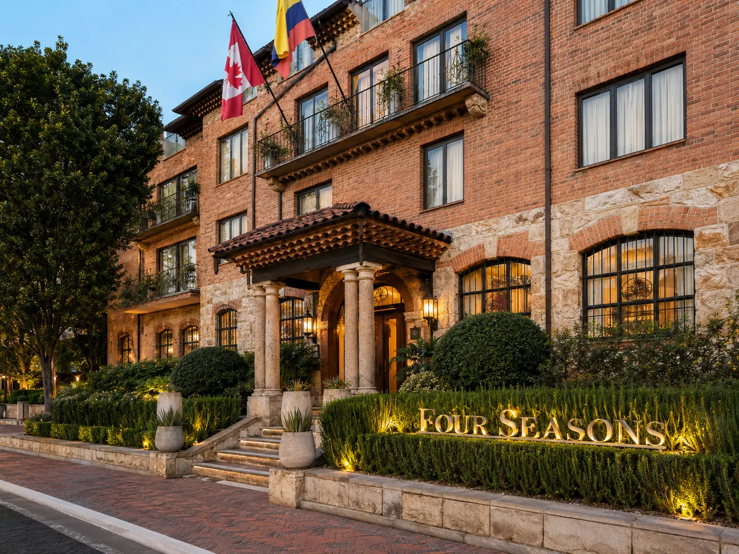 Exterior of Four Seasons Hotel Casa Medina Bogotá with historic brick façade, stone entrance and landscaped gardens. 