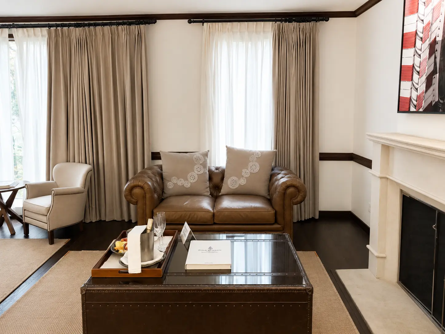 Executive Suite With Fireplace at Four Seasons Hotel Casa Medina Bogotá with king bed, dark wood furniture and classic residential interiors.