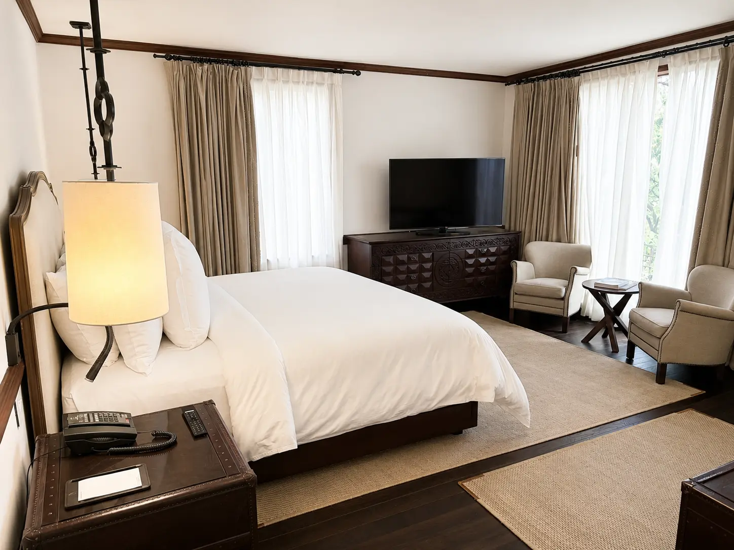 Executive Suite With Fireplace at Four Seasons Hotel Casa Medina Bogotá with king bed, seating area, large windows and dark wood furnishings.