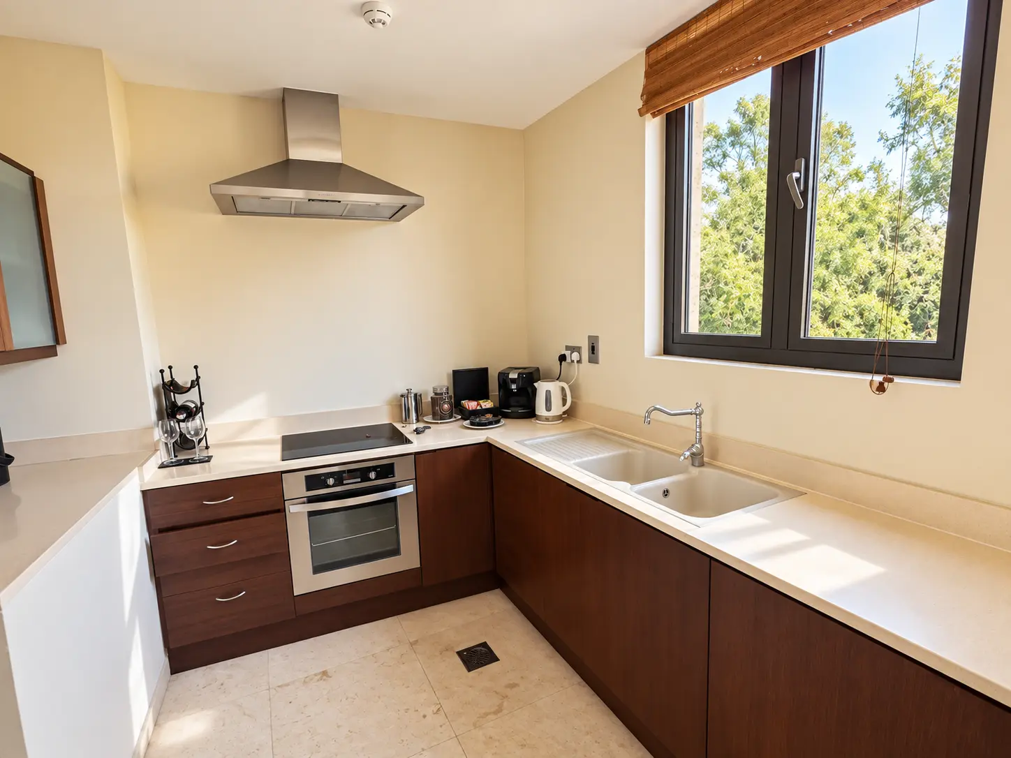 Full kitchen in a One-Bedroom Villa at Four Seasons Safari Lodge Serengeti, Tanzania, with oven, cooktop, double sink and coffee facilities.