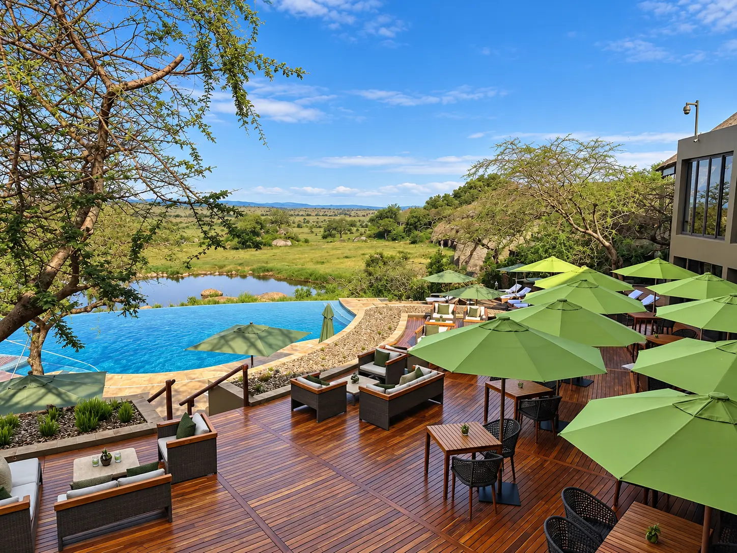 Infinity pool and outdoor terrace at Four Seasons Safari Lodge Serengeti overlooking the watering hole and Serengeti plains.