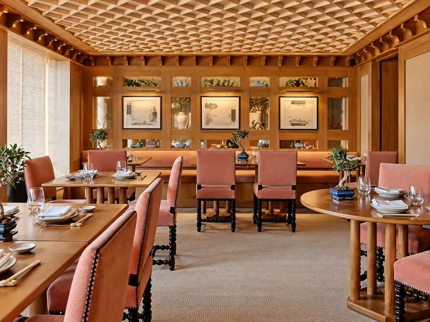 Restaurant at Aman Le Mélézin with warm timber interiors, coral seating and Japanese-inspired design.