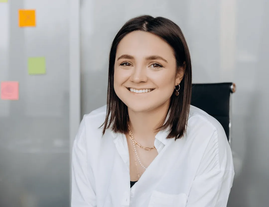A woman sitting at a desk with a smile on her face.