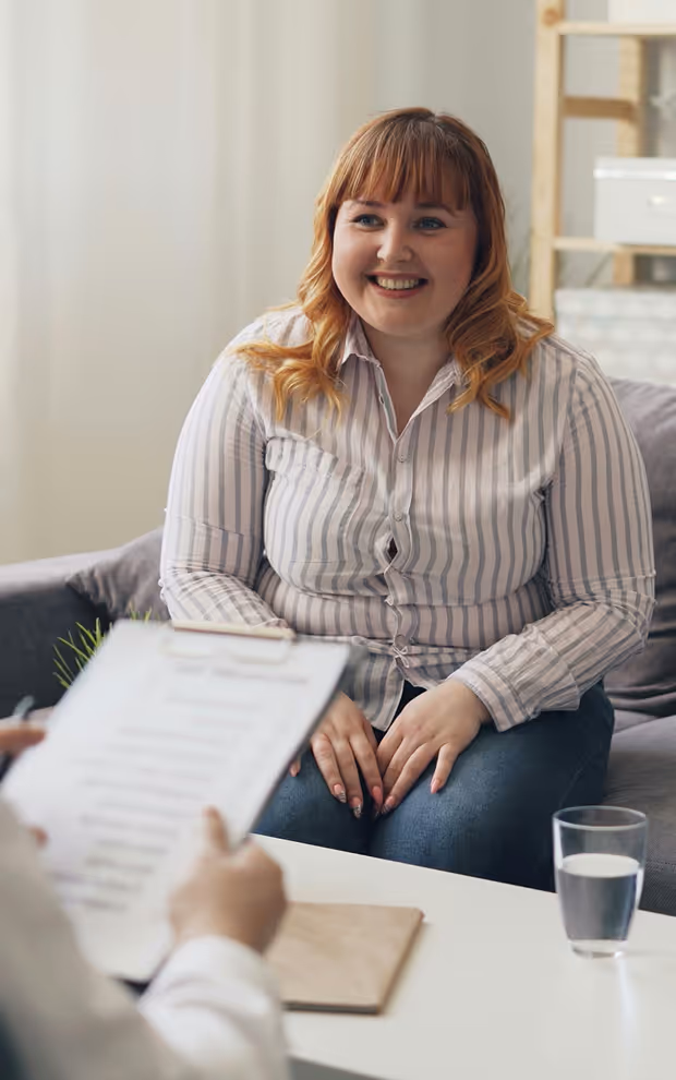 A woman sitting on a couch talking to a man.