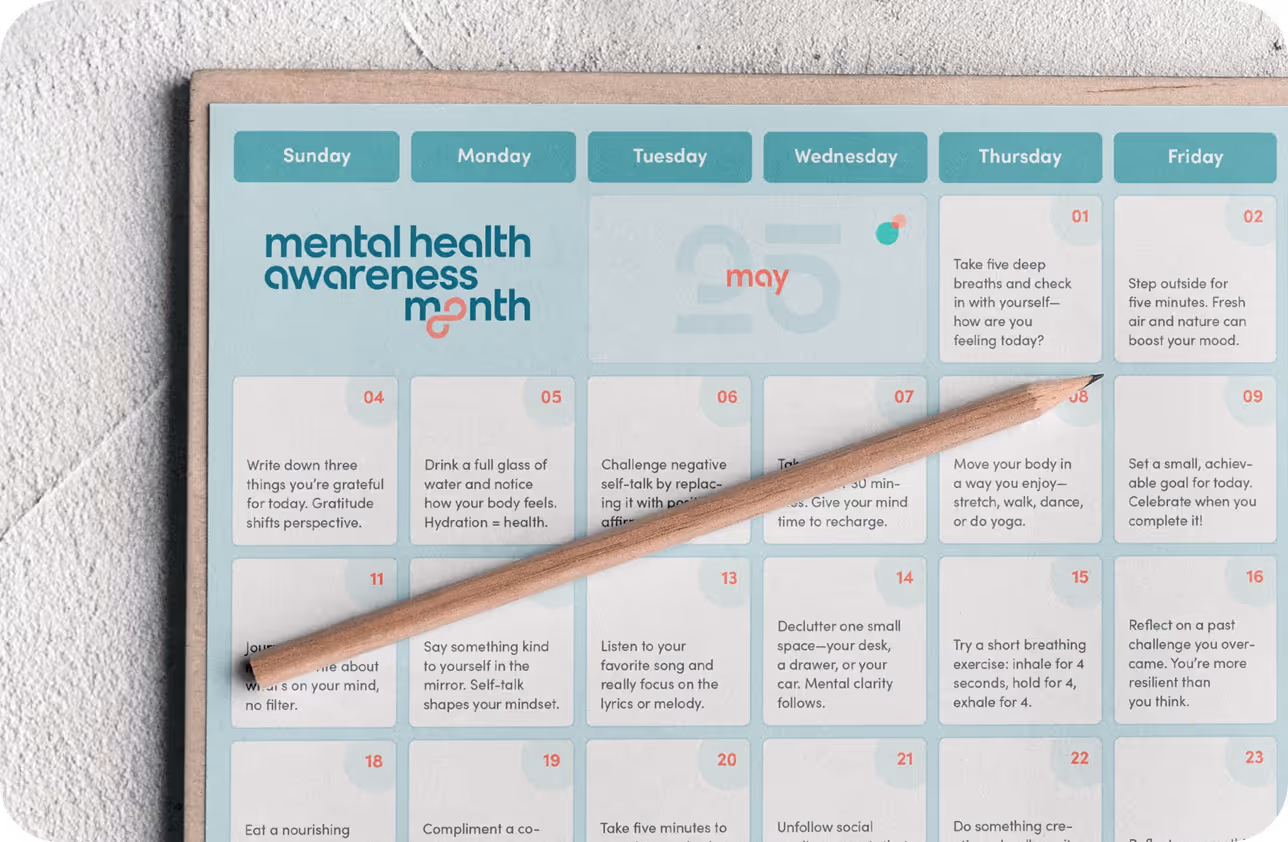 A calendar with a wooden pen on top of it.