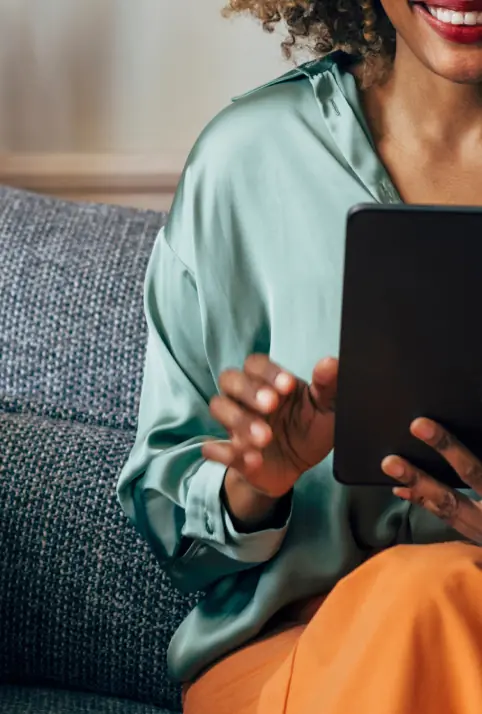 Smiling woman on a sofa using a tablet