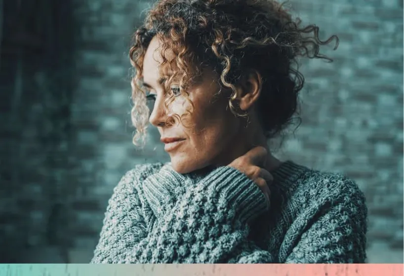 Woman in a knit sweater looking away thoughtfully