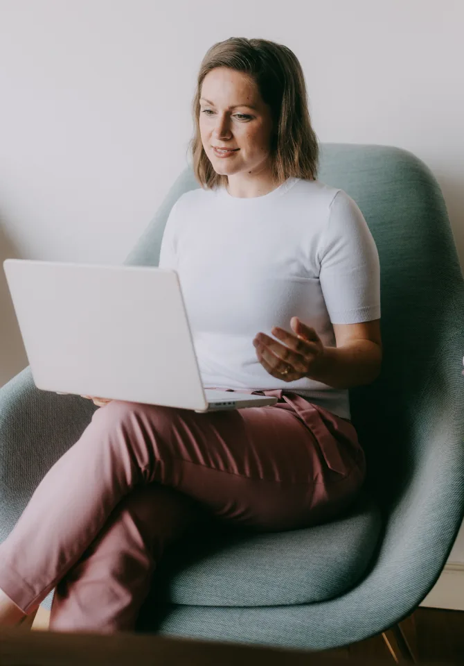 Woman on a virtual therapy session from her armchair at home