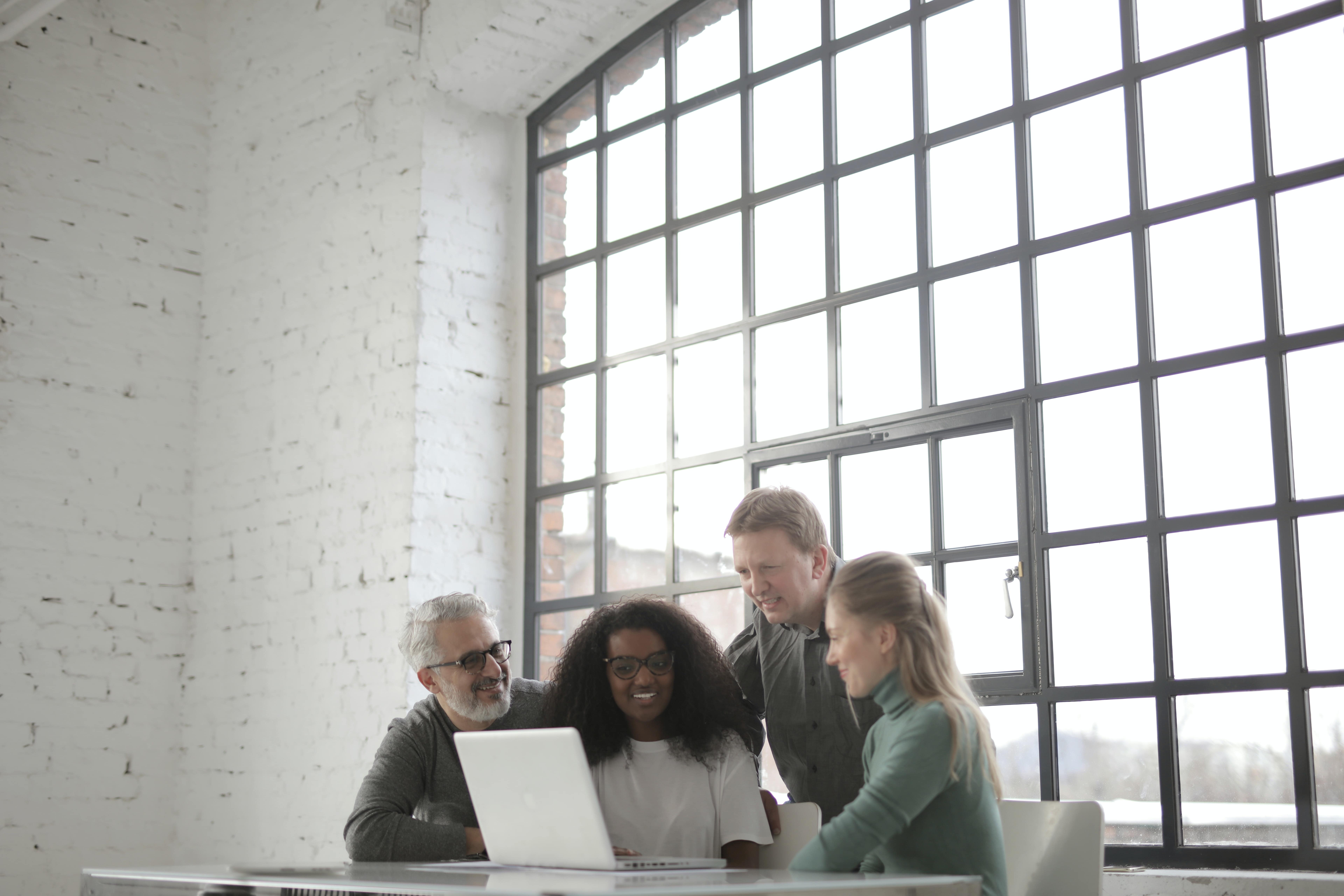 A team surrounding a computer