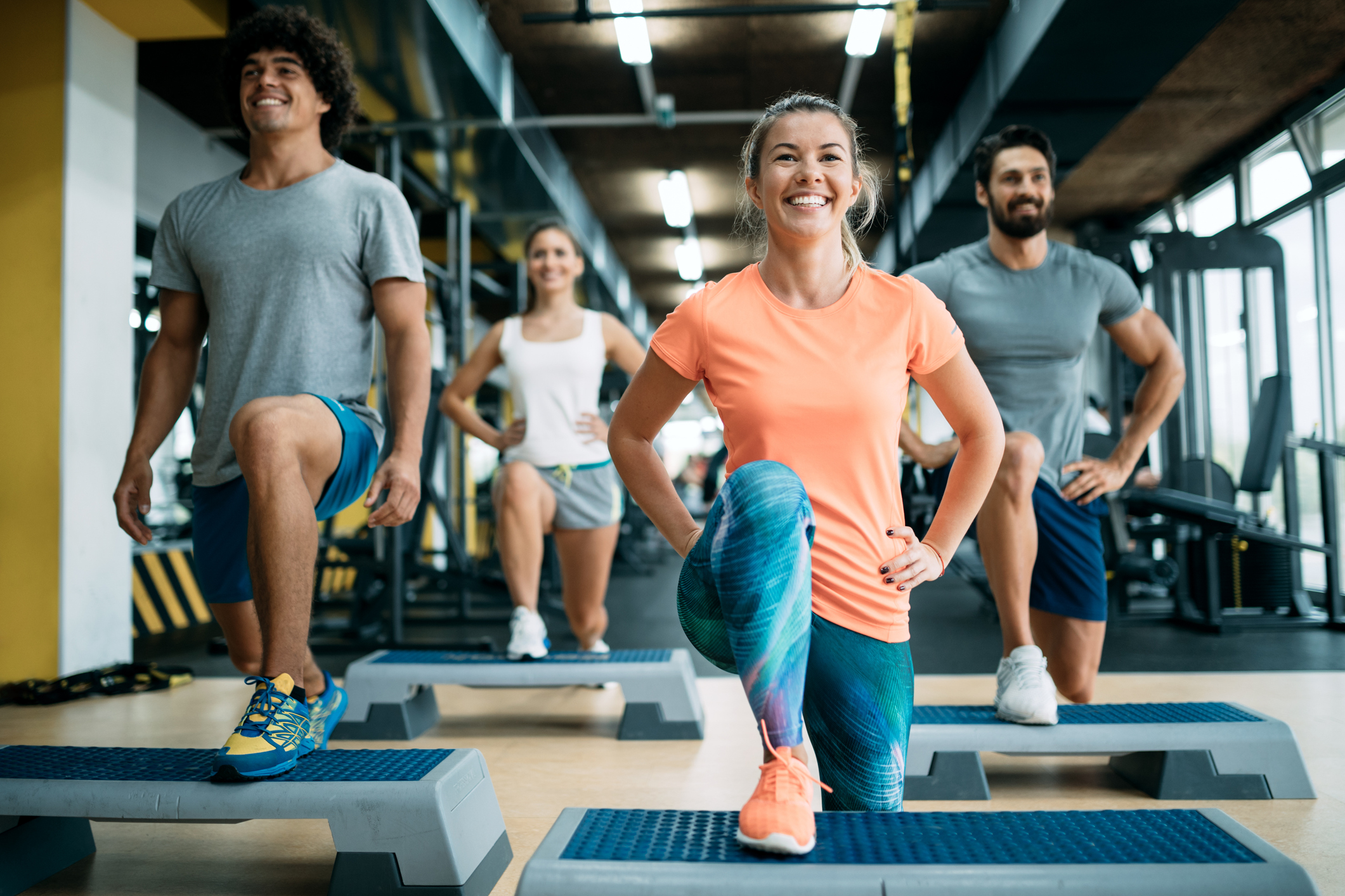 Group of people doing a step aerobics class at the gym