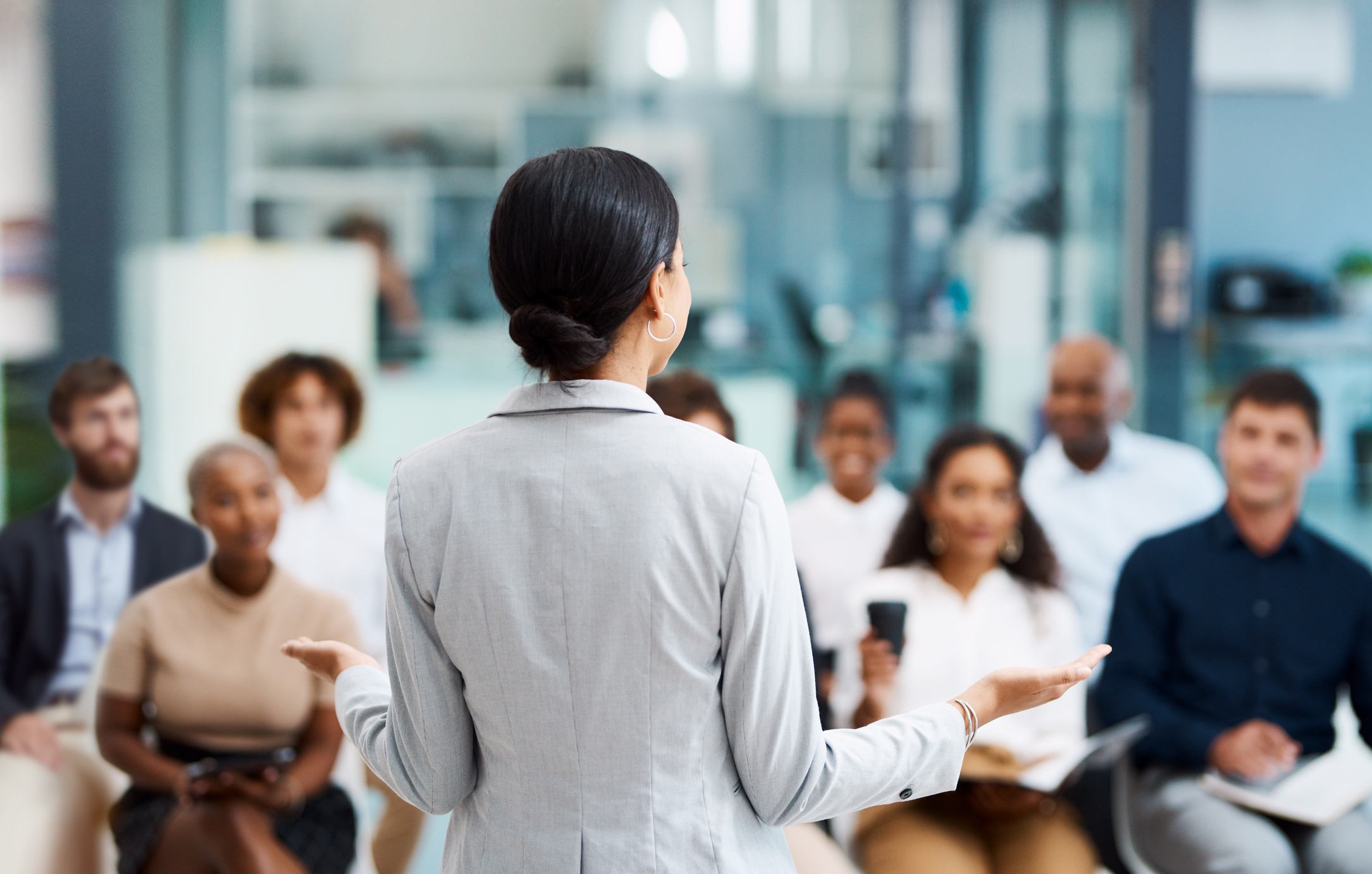 A woman talking in front of the team