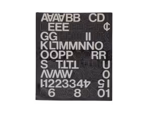 Black stencil plate with uppercase letters, numbers, and symbols arranged in rows and columns.