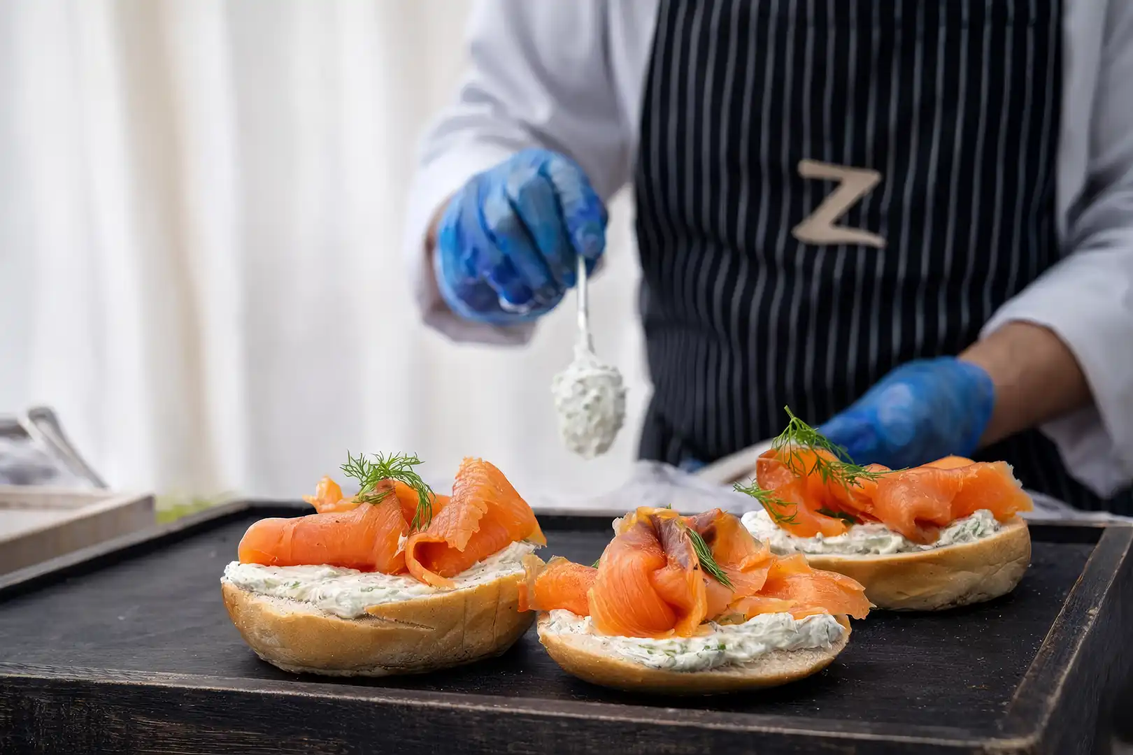 Basket of thick-cut golden French fries garnished with rosemary, served with a round dish of melted cheese and a spoon.