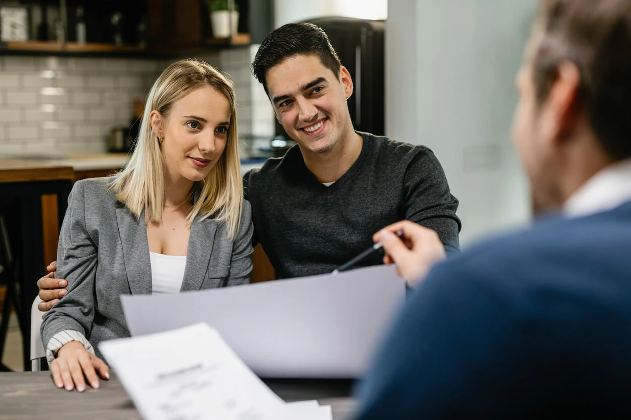 Un couple devant un professionnel tenant un document.