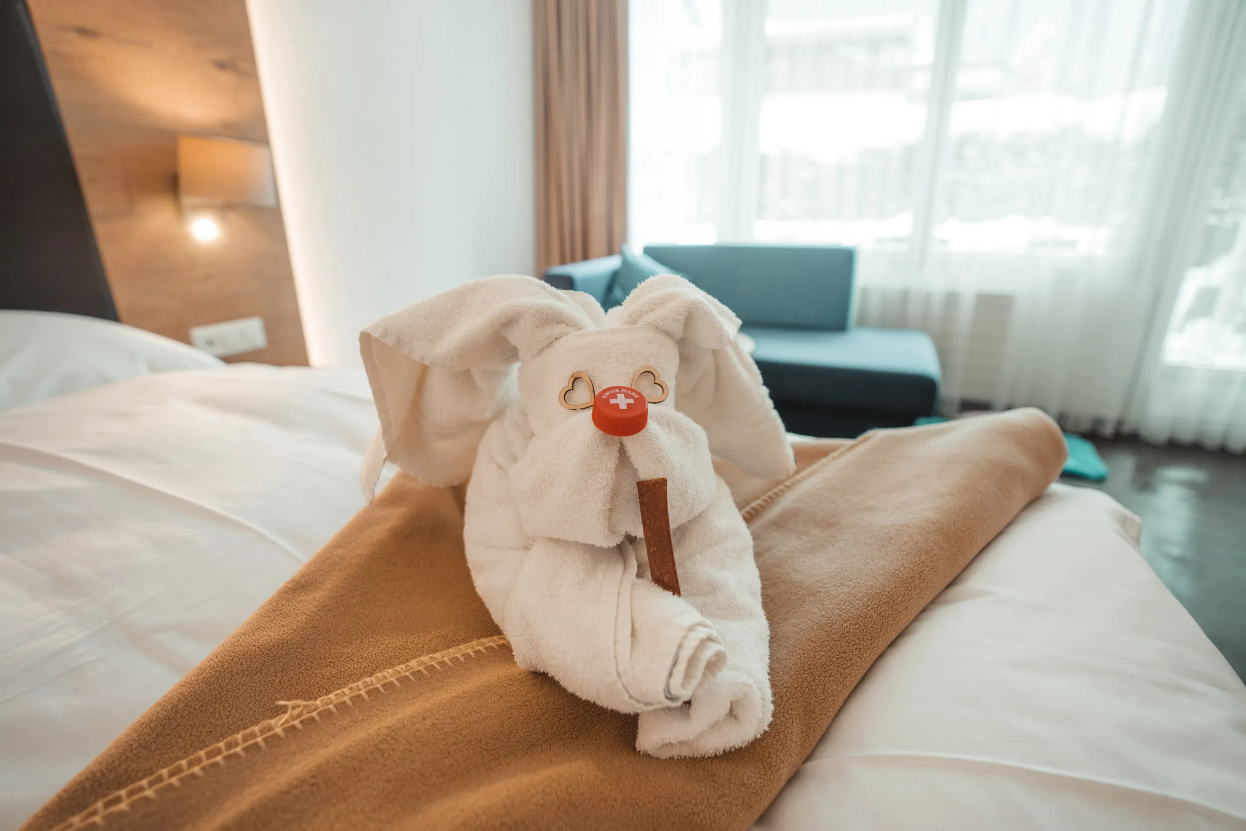 Als Hase gefaltetes Handtuch auf dem Bett im Hotelzimmer