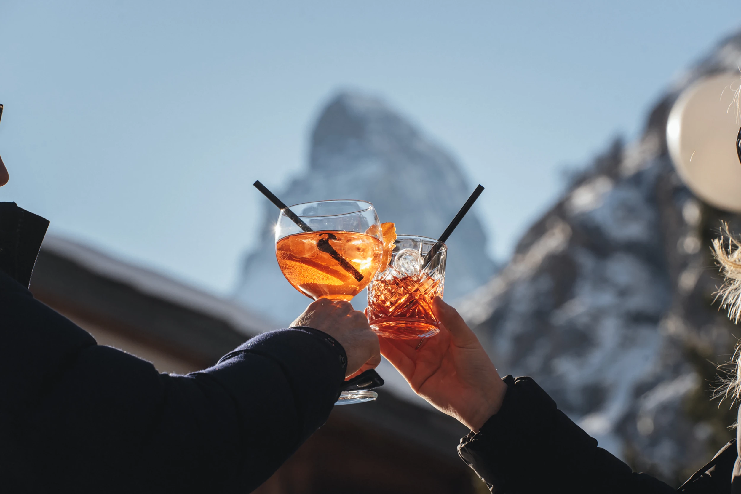 Zwei Apéro-Gläser vor dem Matterhorn beim Anstossen