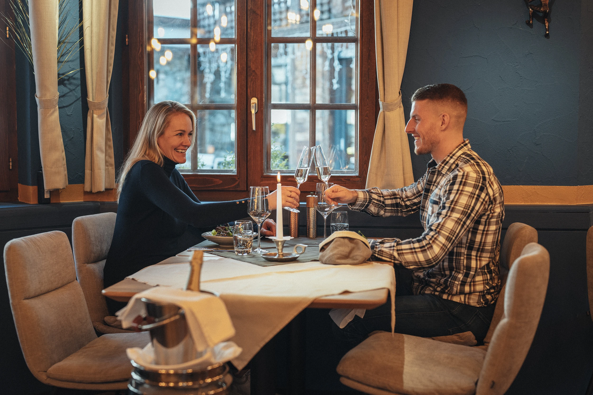 Paar stösst beim Candle-Light-Dinner im Restaurant PeakFine an
