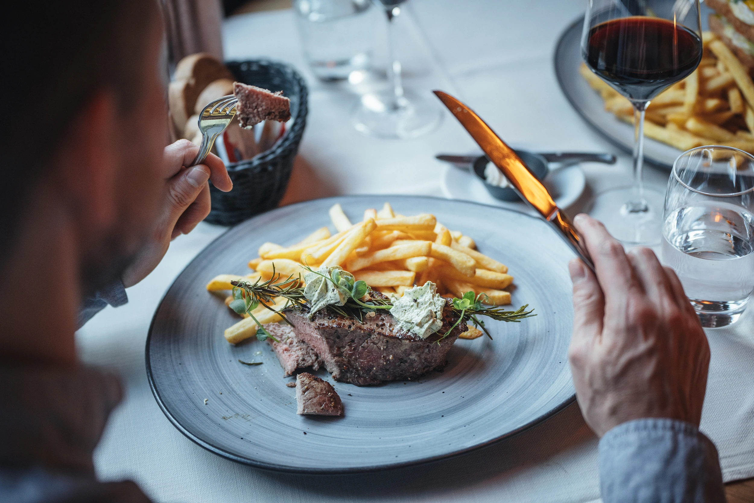 Gast geniesst Entrecôte mit Pommes frites im Restaurant PeakFine