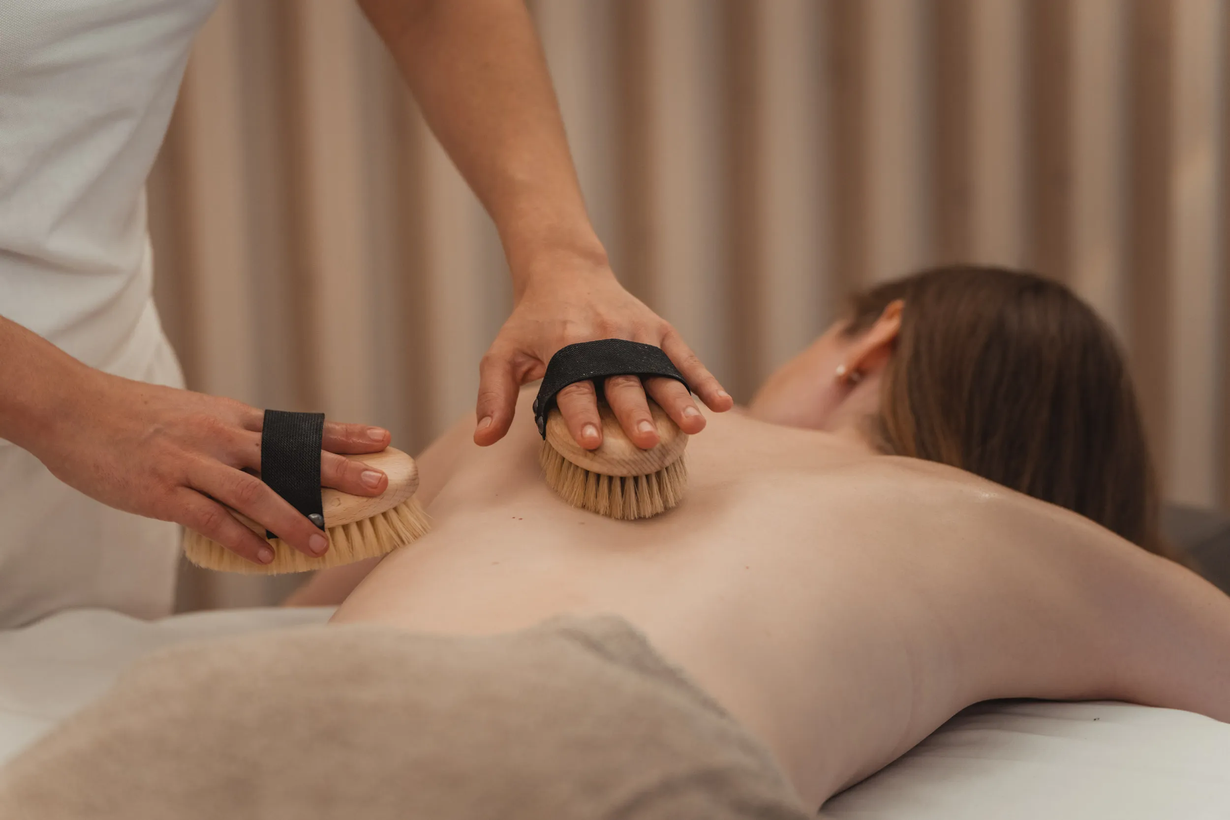 Bürstenmassage am Rücken im Spa des Alpen Resort