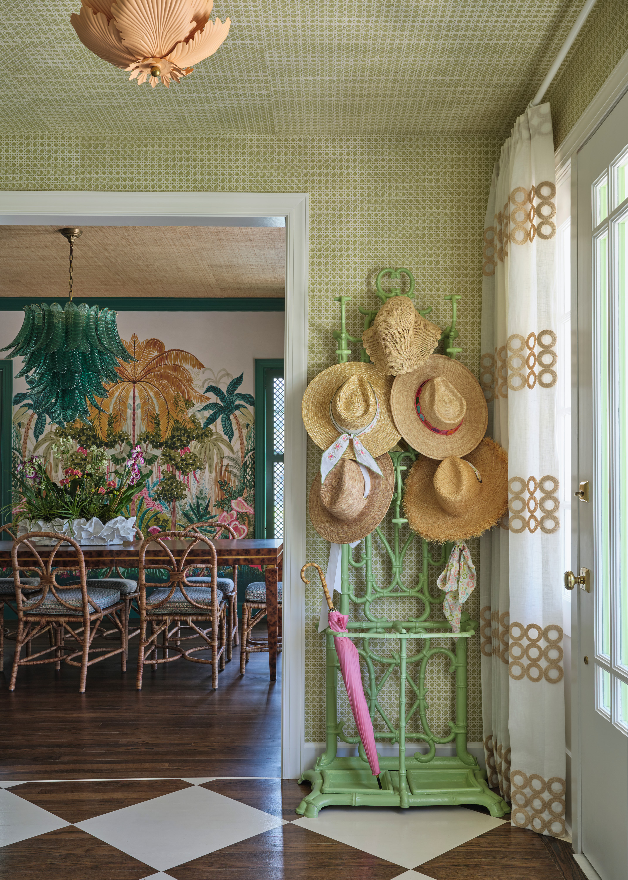 Entryway with a green hat stand and a view into the dining room.