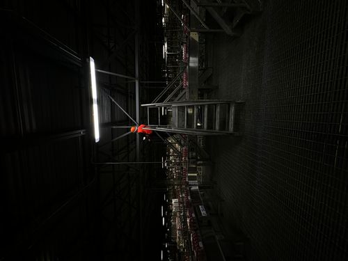Dark industrial interior with equipment lit by a narrow beam of light