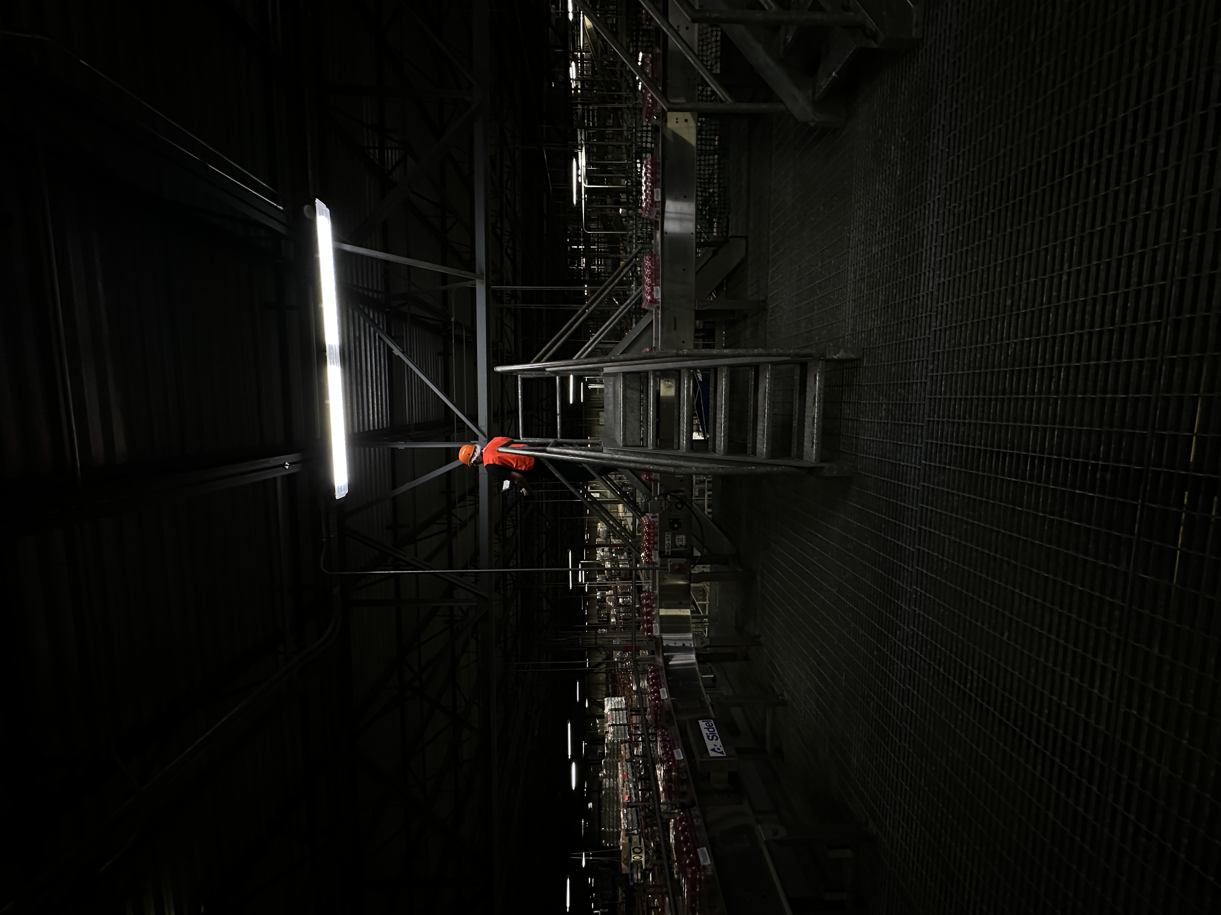 Dark industrial interior with equipment lit by a narrow beam of light