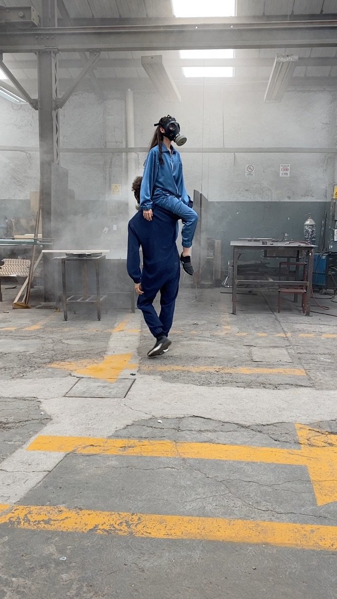 Person in blue protective clothing walking through an industrial space
