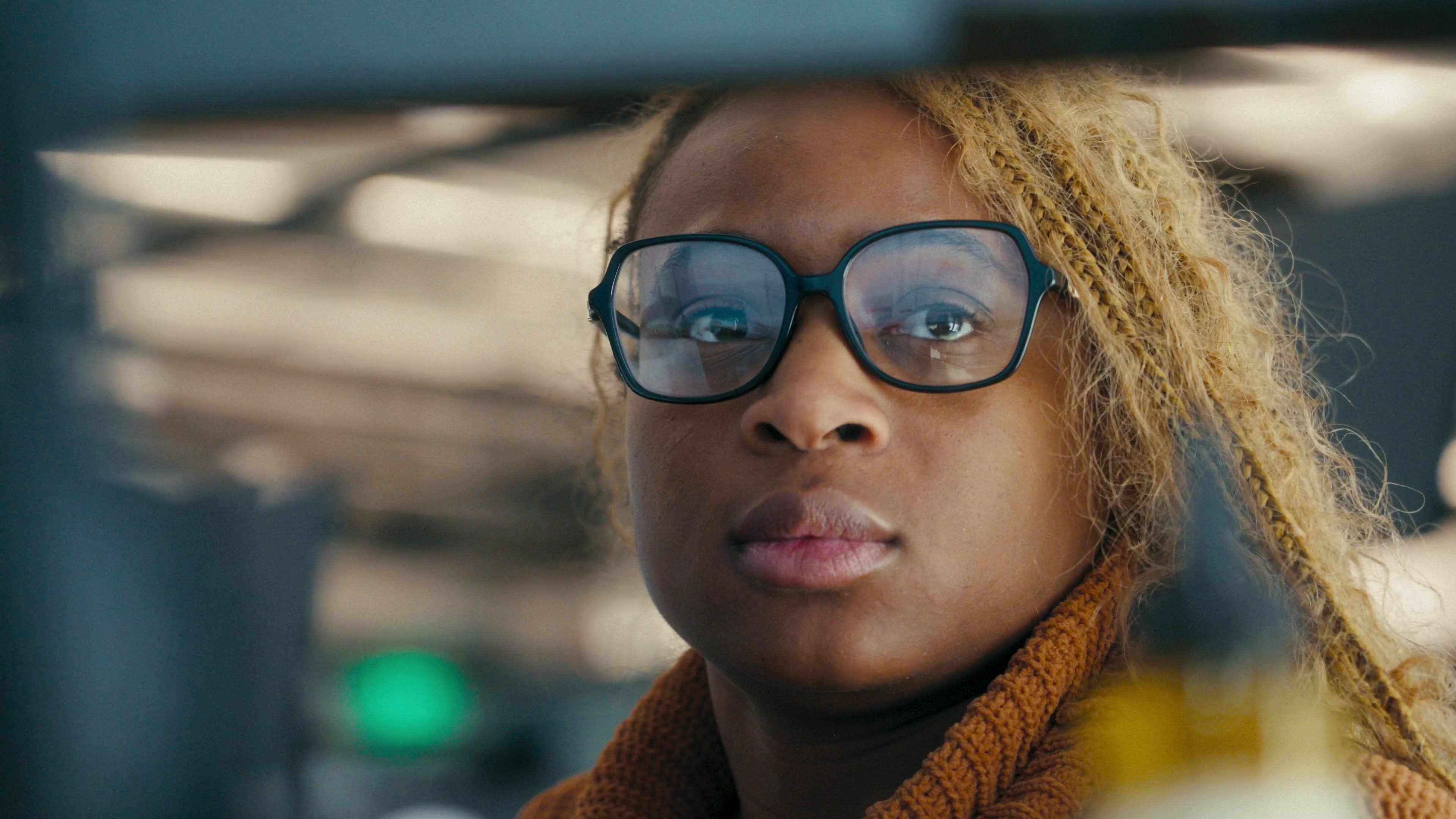 Close-up of an MN8 employee in glasses, in a scene from The Adventure Begins