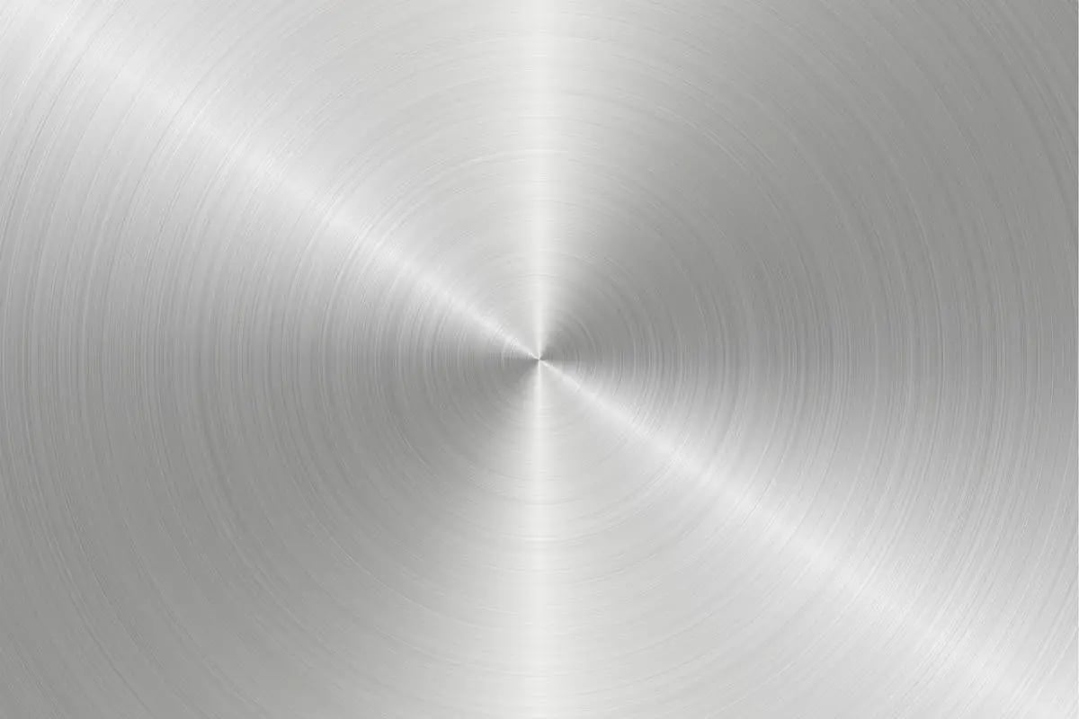 Close-up of a circular brushed metal texture with radial lines converging at the center.