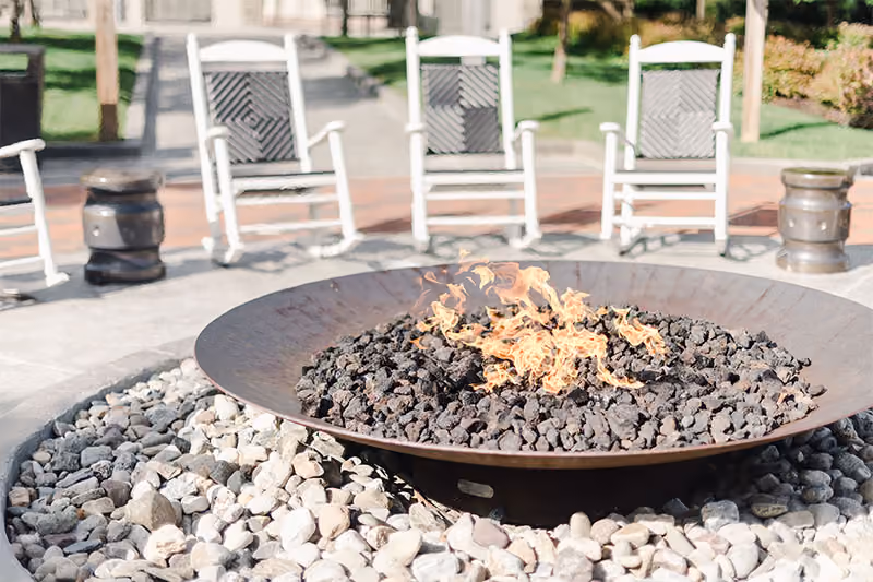 Guests gathering around a fire pit on the terrace at The Inn, Chesapeake Bay Beach Club, Kent Island, Maryland