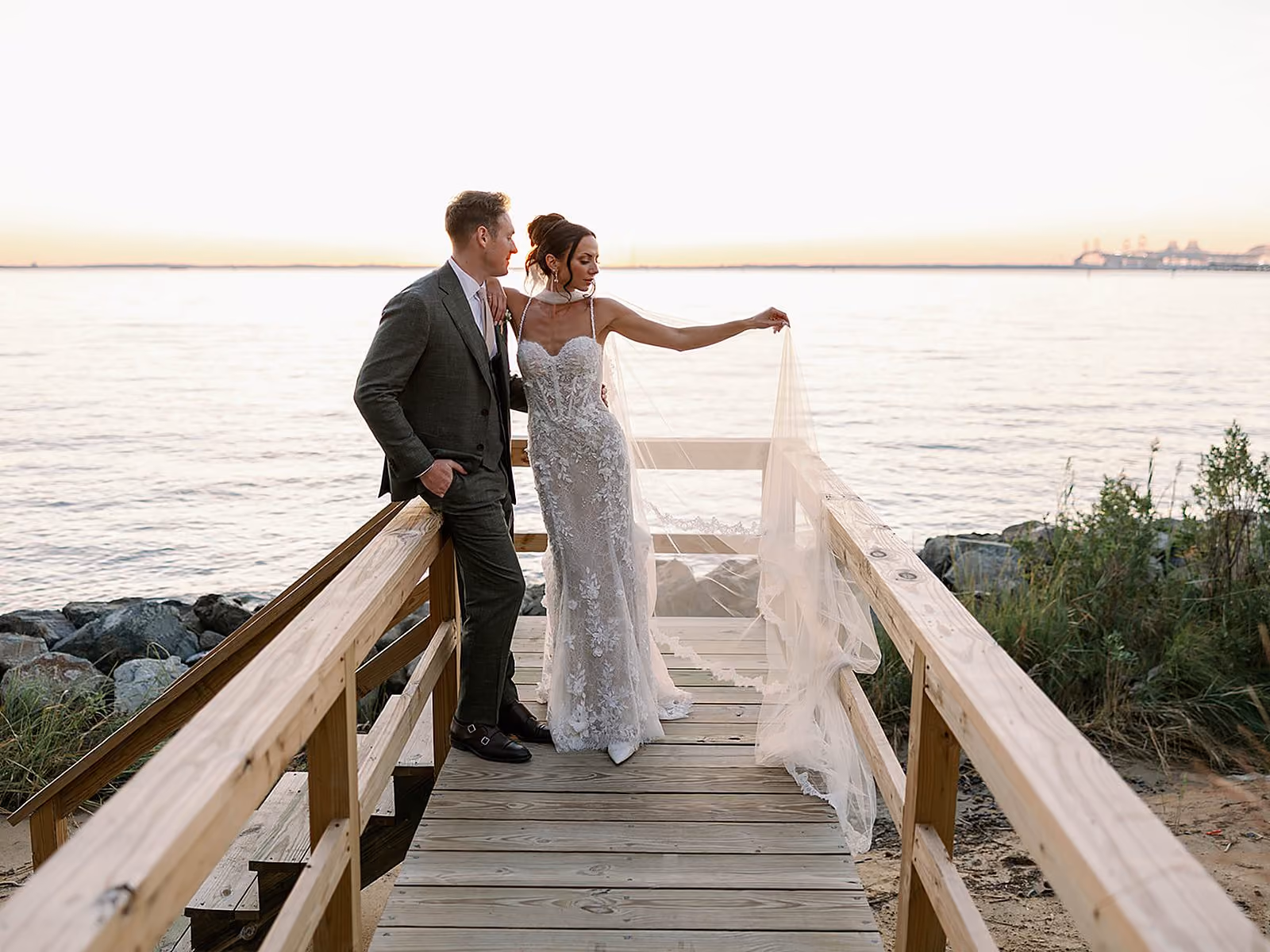 Bride and groom sharing a moment on a wooden waterfront dock at sunset along the Chesapeake Bay