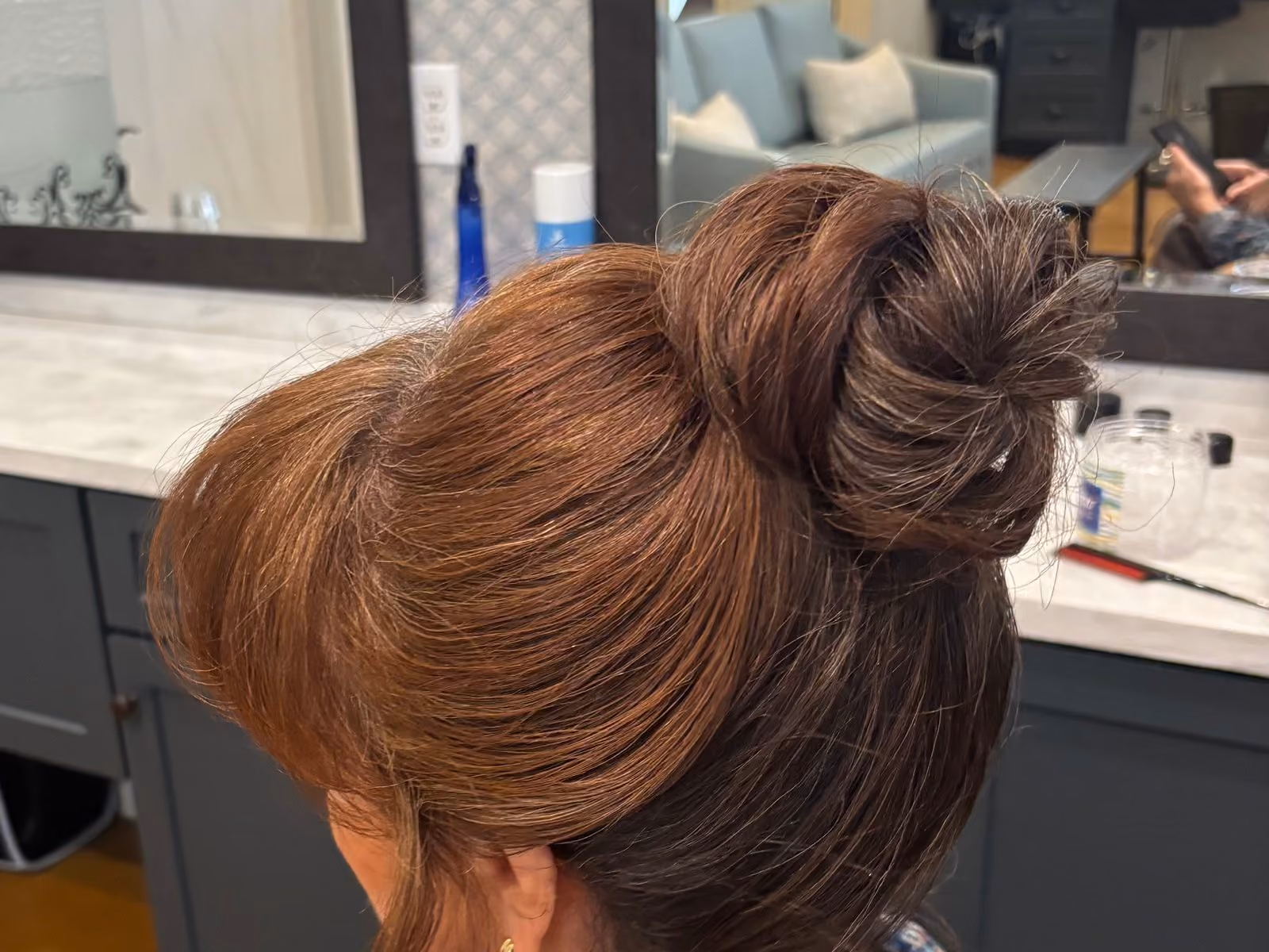 Elegant high updo bun bridal hairstyle viewed from behind in the styling salon