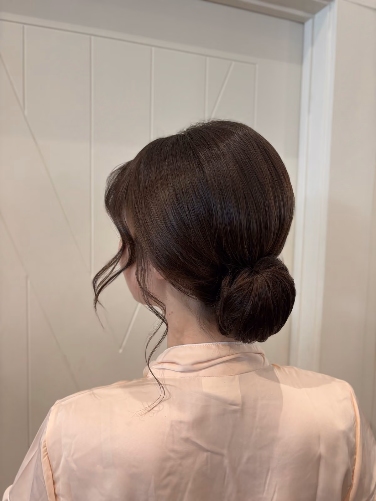 Low bun bridal chignon with face-framing wisps at Chesapeake Bay Beach Club