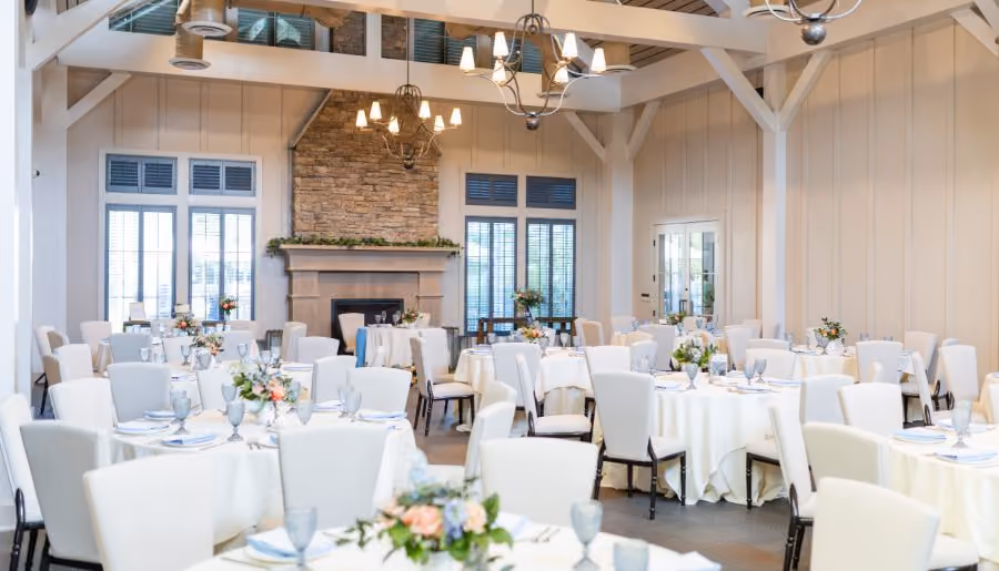 The Inn Ballroom with cathedral ceilings, stone fireplace, and round banquet tables at Chesapeake Bay Beach Club