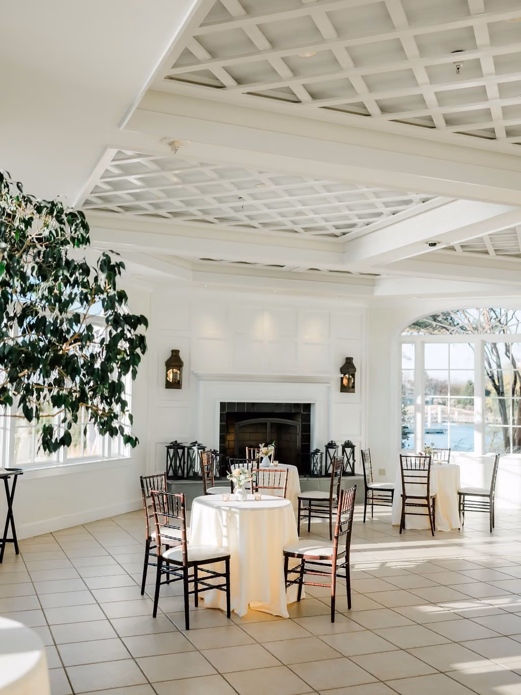 Garden Room with greenery, entry-wall fireplace, and an intimate dining table at Chesapeake Bay Beach Club