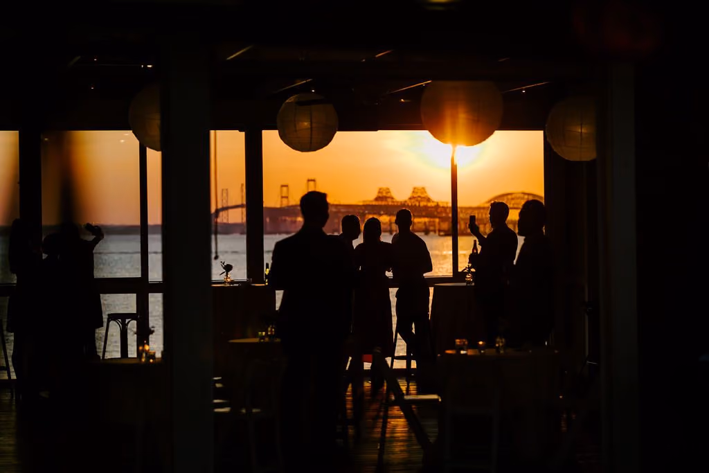 Guests silhouetted against a Chesapeake Bay sunset at Tavern Bayside, Chesapeake Bay Beach Club