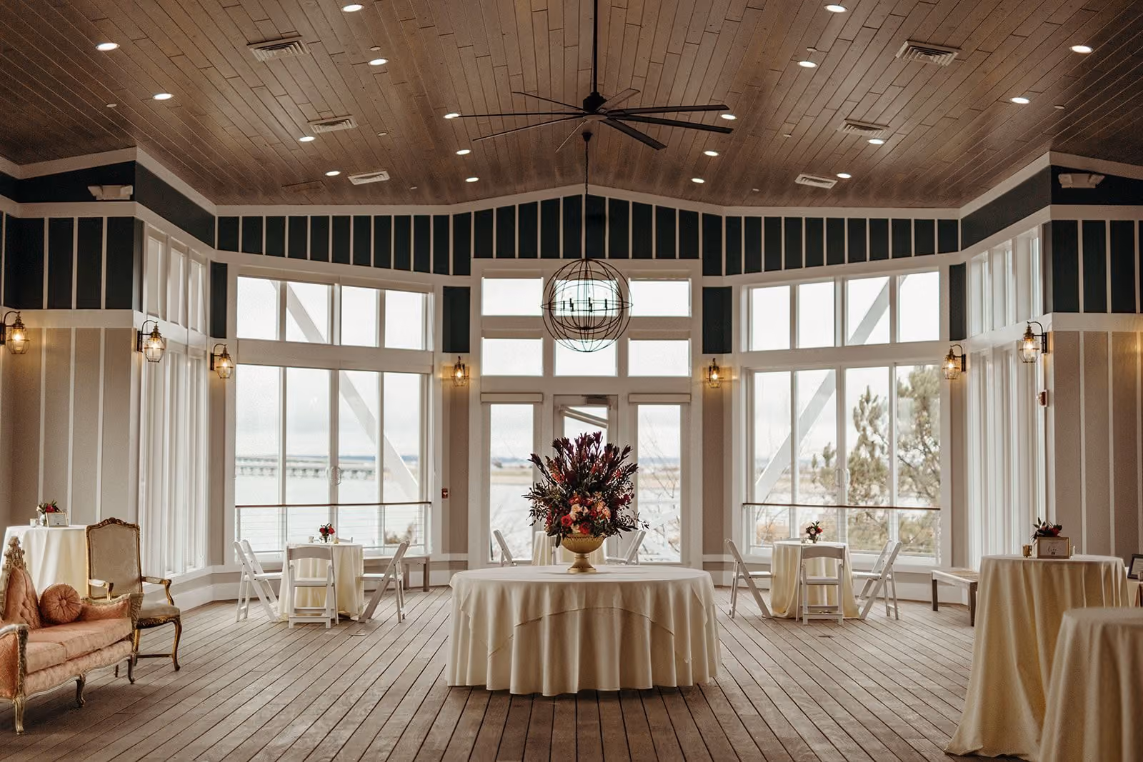 Garden Rooftop with floor-to-ceiling bay-view windows and cocktail tables set for an event at Chesapeake Bay Beach Club