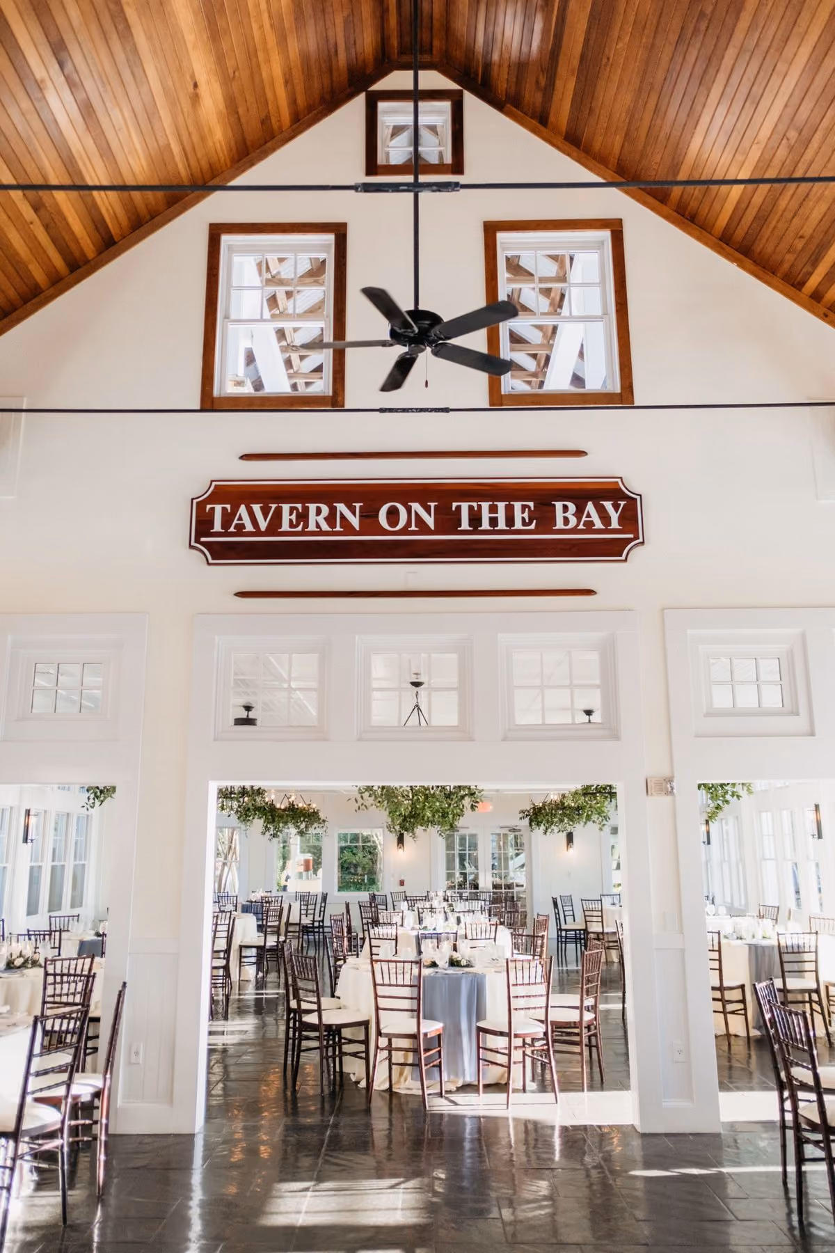 Tavern Ballroom vaulted interior with the Tavern on the Bay sign and event tables at Chesapeake Bay Beach Club