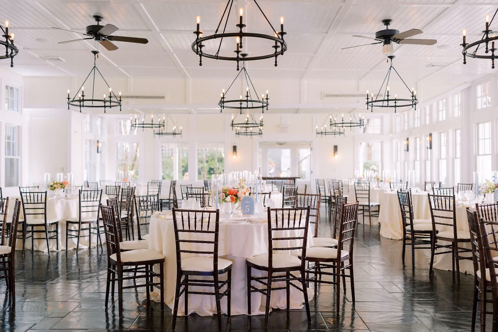 Tavern Ballroom with dramatic vaulted wood ceiling, iron chandeliers, and round banquet tables at Chesapeake Bay Beach Club