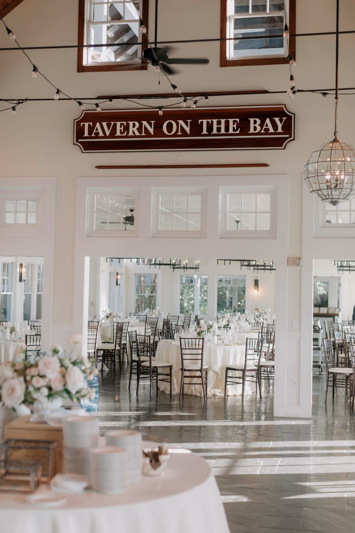Tavern Ballroom interior with the Tavern on the Bay sign and natural light through glass doors at Chesapeake Bay Beach Club