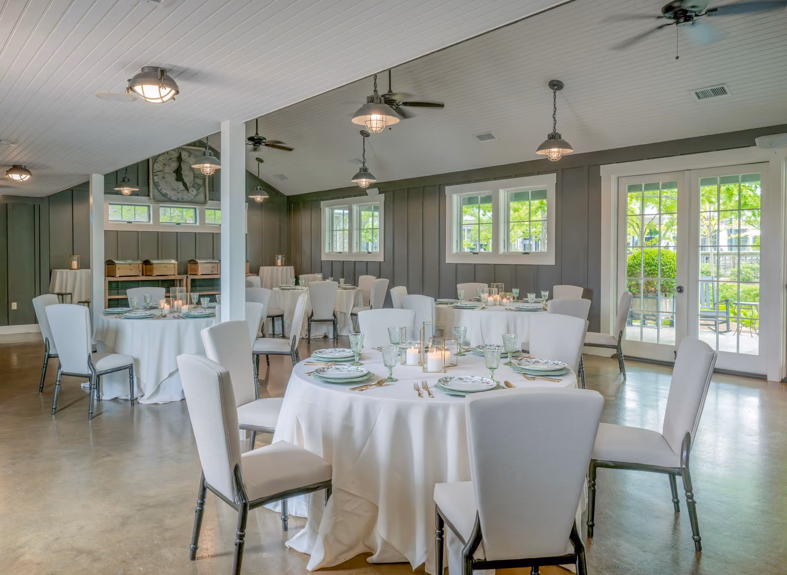 Tool Shed Bar set with round dining tables, ceiling fans, and garden-view windows at The Inn at Chesapeake Bay Beach Club