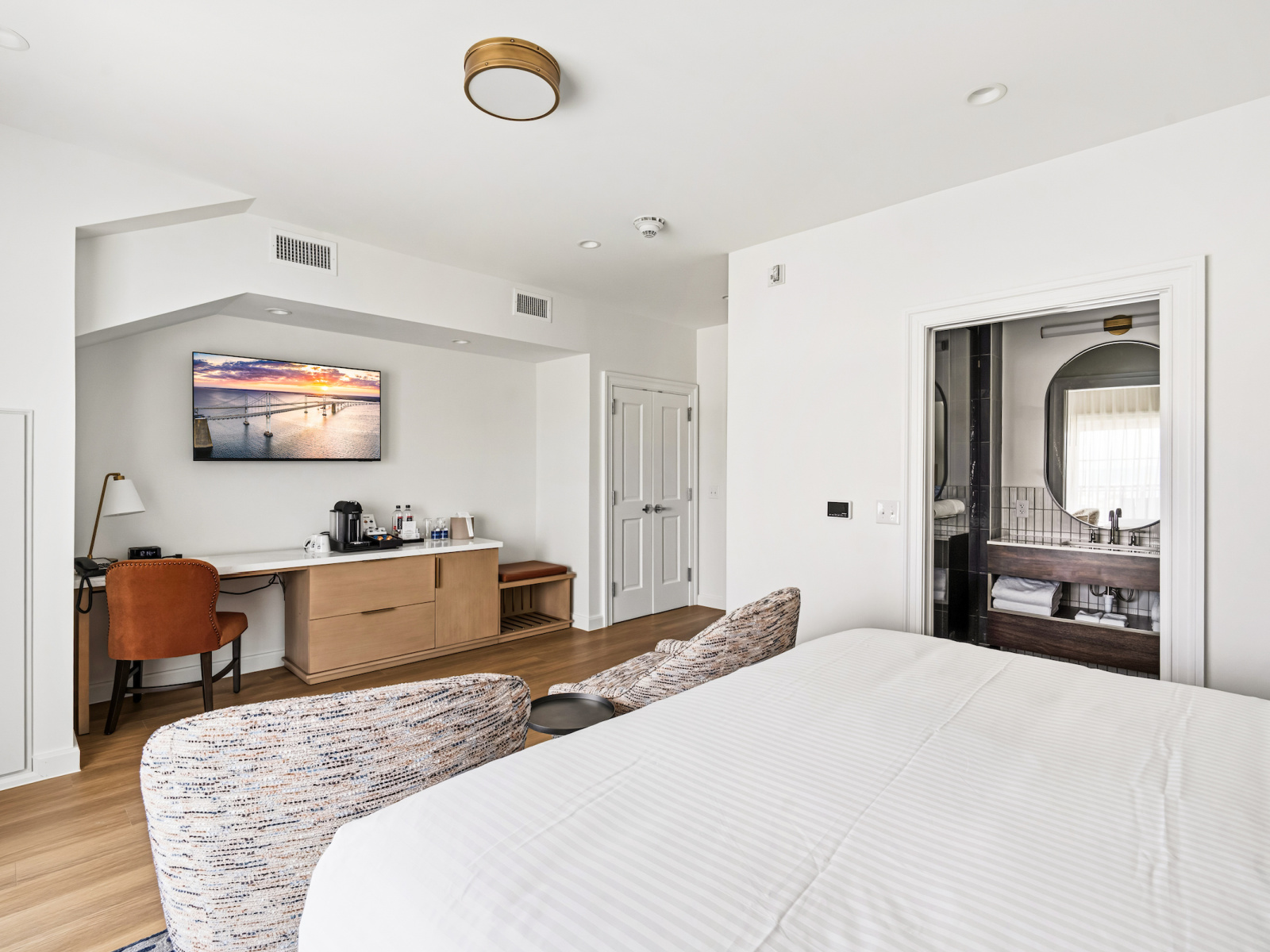 King Premier Guest Room at Wilson’s Cove featuring a king bed, coastal furnishings, desk and coffee station.