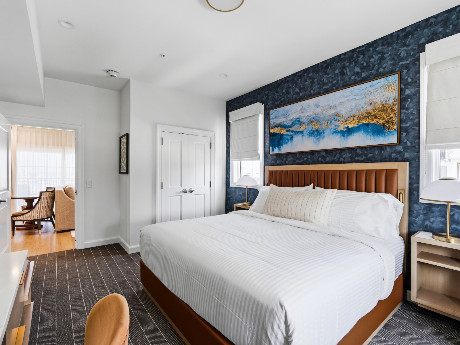 Wilson’s Cove Mariner Suite king bedroom with coastal blue accents and adjoining living area