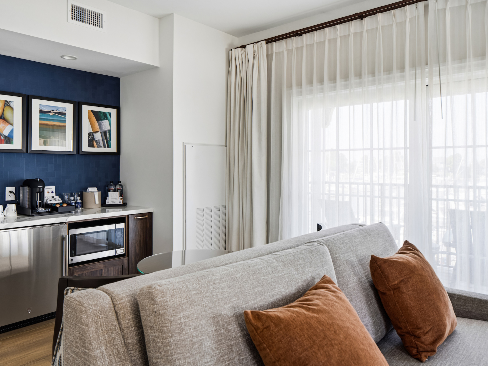 Mariner Suite living area at Wilson’s Cove with sofa, dining table and private balcony.