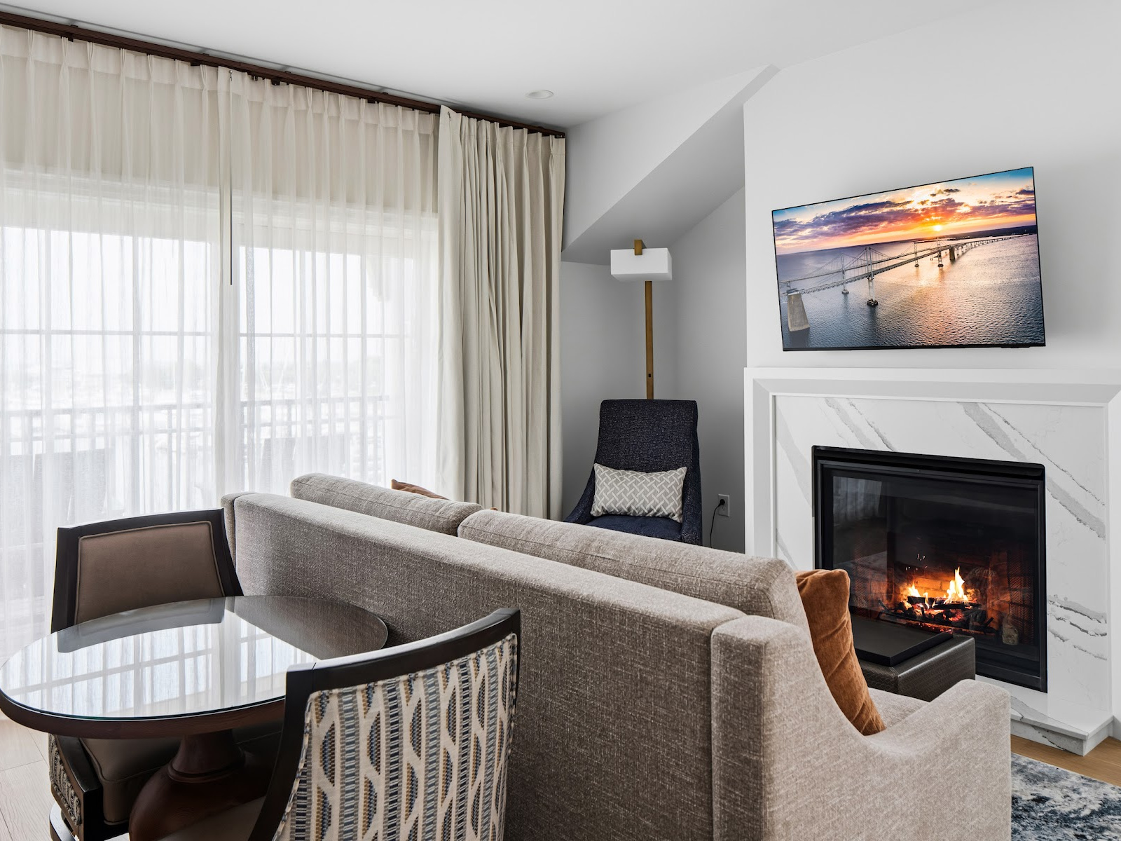 Anchor Suite living room at Wilson’s Cove with fireplace, dining area and private balcony.
